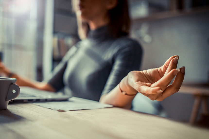 worker peacefully meditating at desk