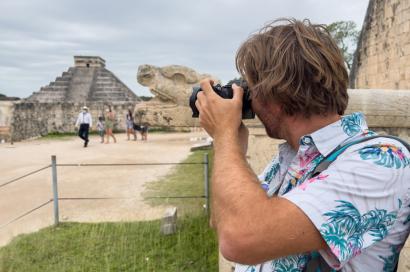 Male tourist in Hawaiian shirt taking picture of pyramids