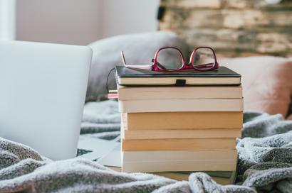 A stack of books next to a computer