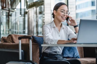 Woman talking on the phone while using her laptop