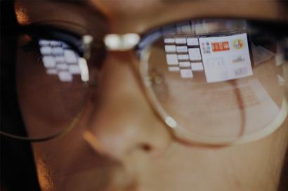 Image: extreme close up of woman's face with browsers reflected on the glasses